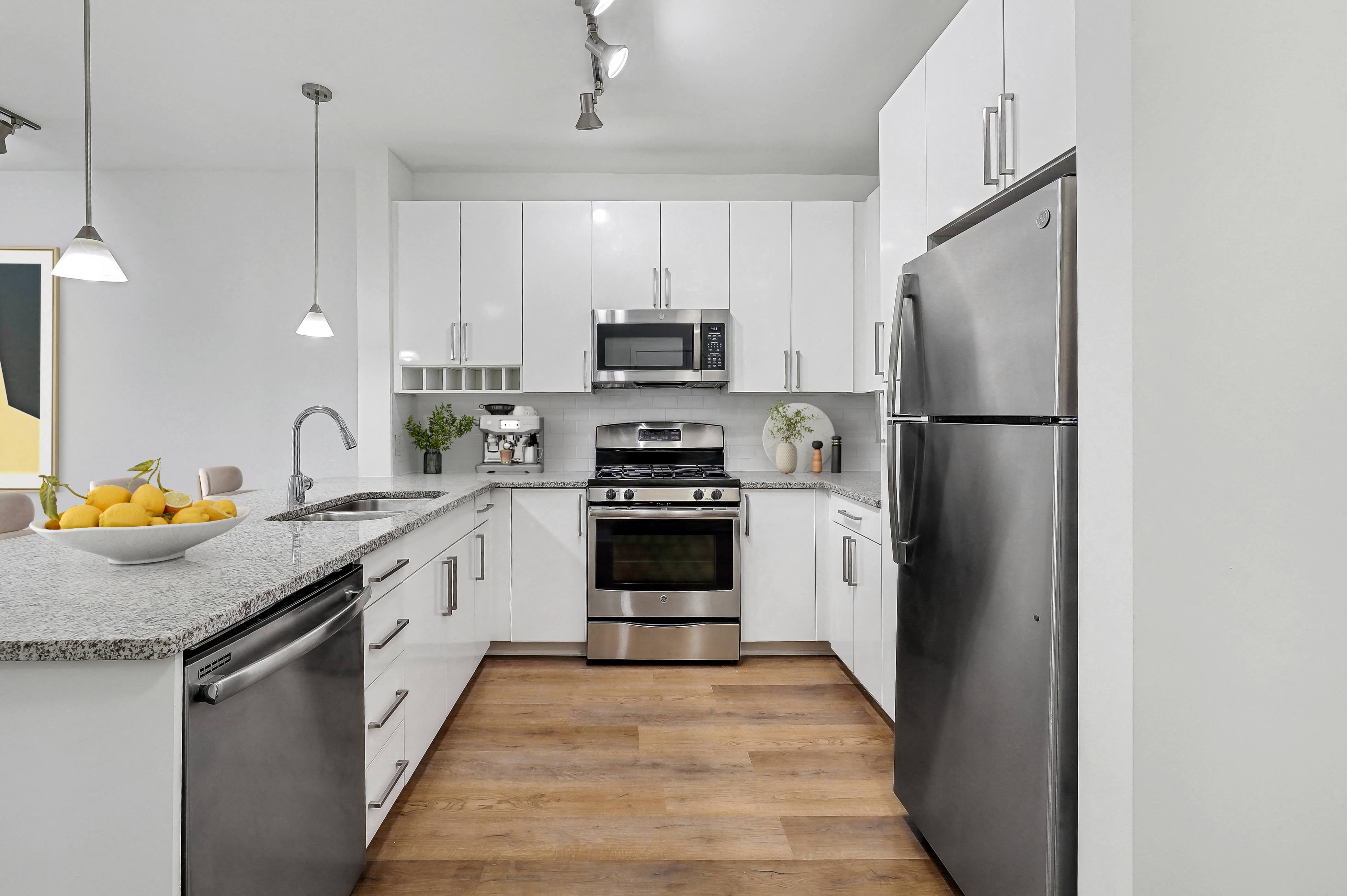 a modern kitchen with stainless steel appliances and white cabinets